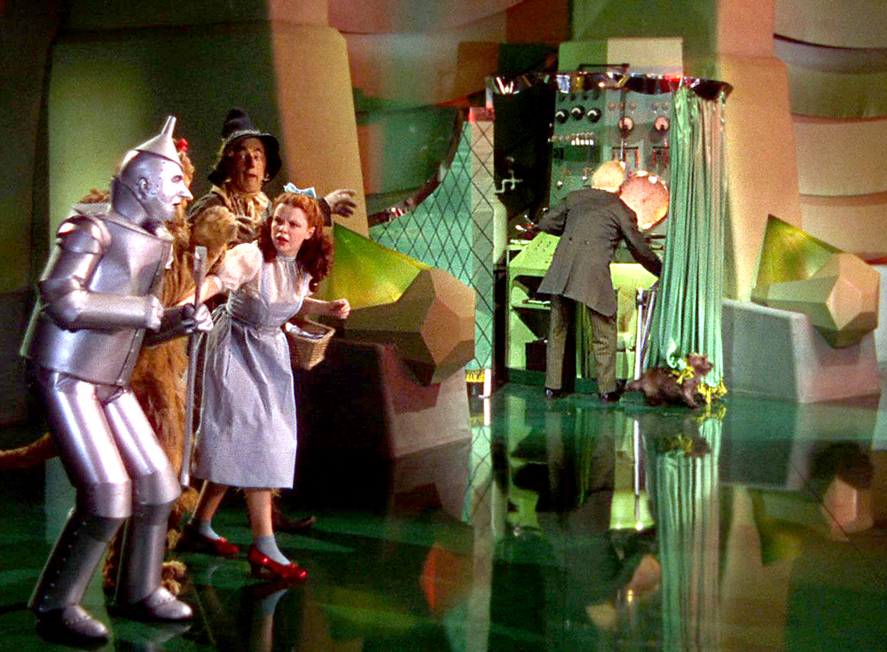 Screencap from the Wizard of Oz movie, where the gang peeks behind the curtain